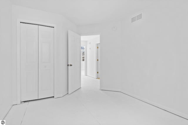 unfurnished bedroom with a closet, visible vents, and baseboards