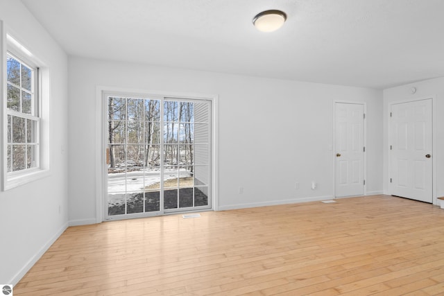 unfurnished room featuring baseboards and light wood finished floors