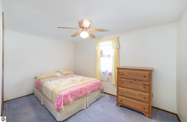 carpeted bedroom featuring baseboards and ceiling fan