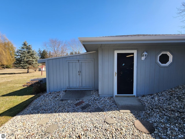 view of exterior entry with a lawn