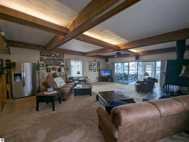 living area featuring beam ceiling, a healthy amount of sunlight, light carpet, and ceiling fan