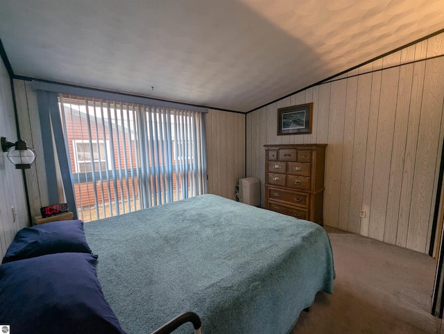 carpeted bedroom featuring wood walls and lofted ceiling