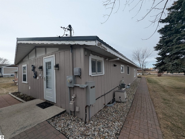 view of property exterior with metal roof and a lawn