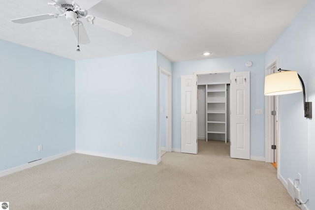 unfurnished bedroom featuring a ceiling fan, light colored carpet, baseboards, and a closet