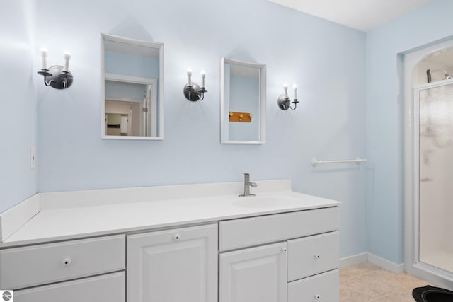 full bathroom with baseboards, a stall shower, vanity, and tile patterned flooring