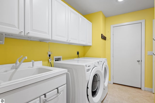 washroom with washer and clothes dryer, cabinet space, baseboards, and a sink