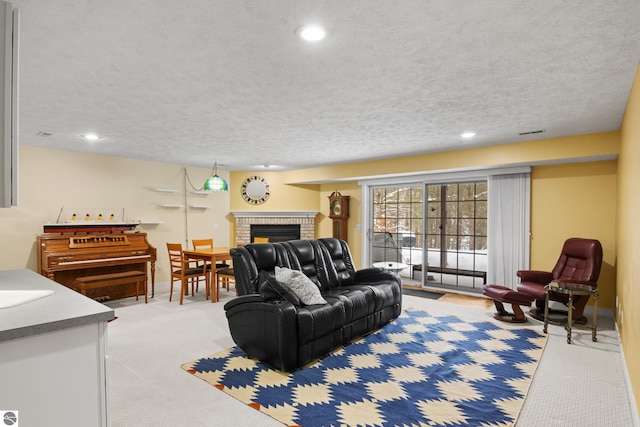 living room featuring recessed lighting, light colored carpet, a textured ceiling, and a fireplace