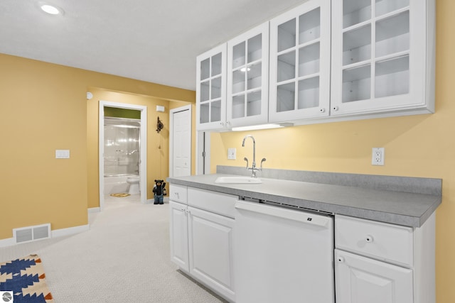 kitchen with visible vents, white cabinetry, glass insert cabinets, dishwasher, and light colored carpet