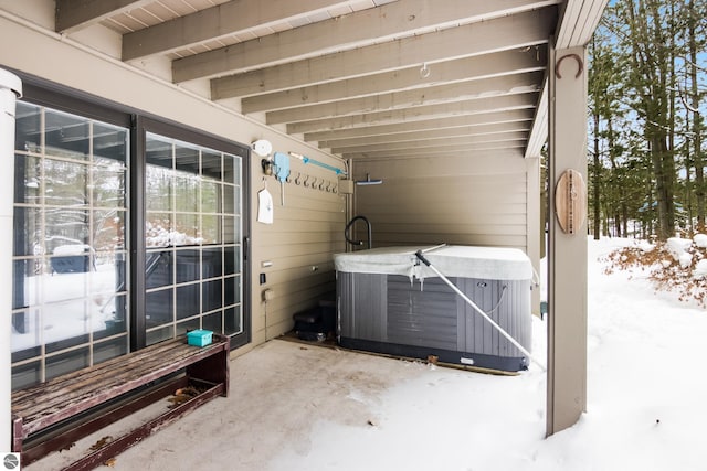 snow covered patio featuring a hot tub