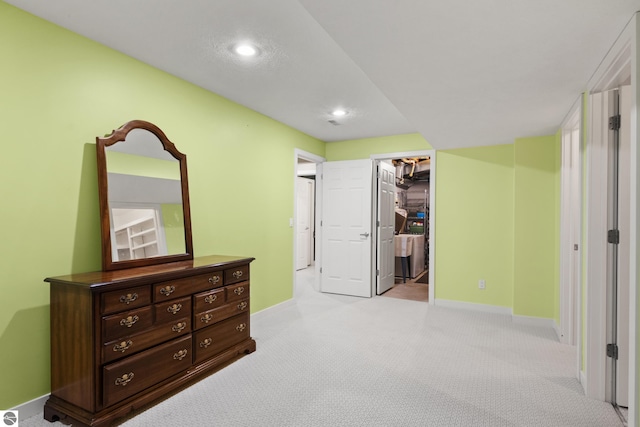 bedroom featuring a spacious closet, recessed lighting, light colored carpet, and baseboards