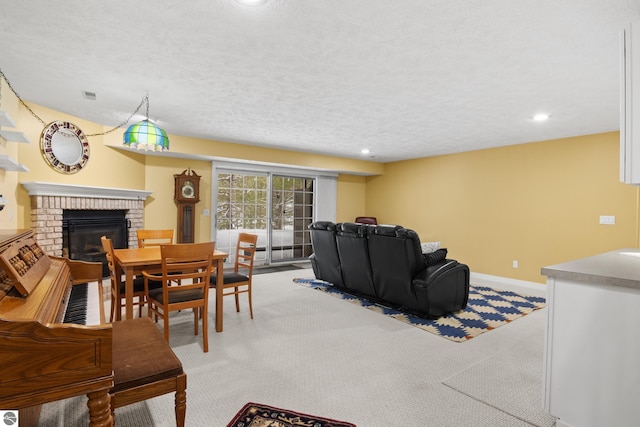 carpeted living room with visible vents, baseboards, recessed lighting, a textured ceiling, and a brick fireplace