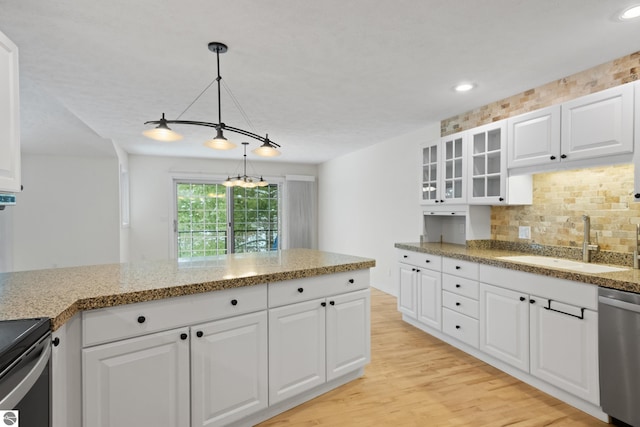 kitchen with a sink, glass insert cabinets, light wood-style floors, dishwasher, and tasteful backsplash