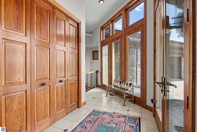 doorway with light tile patterned floors, french doors, and baseboards