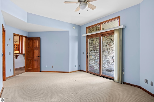 carpeted empty room featuring a ceiling fan and baseboards