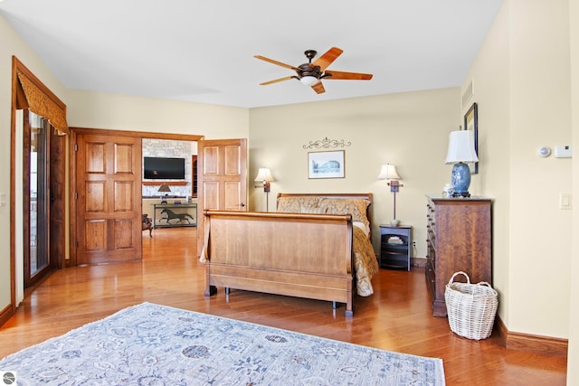 bedroom with visible vents, baseboards, and wood finished floors