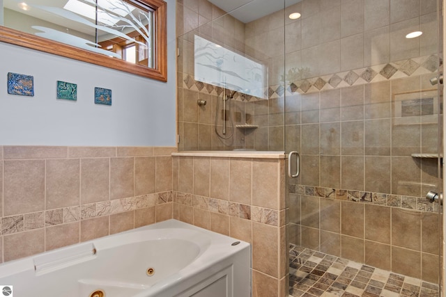 bathroom featuring a tub with jets and a shower stall