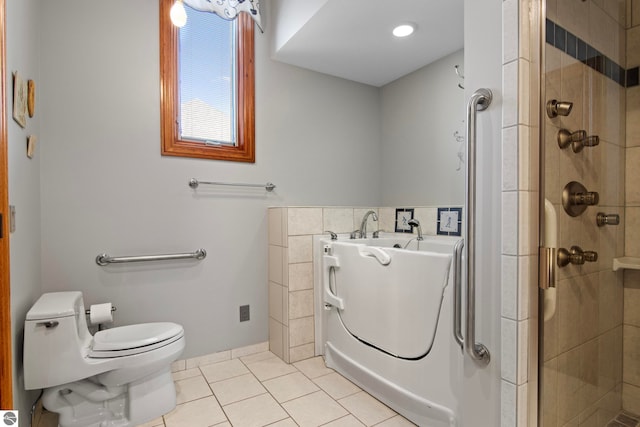 full bathroom featuring tile patterned floors, toilet, a bath, and a shower stall