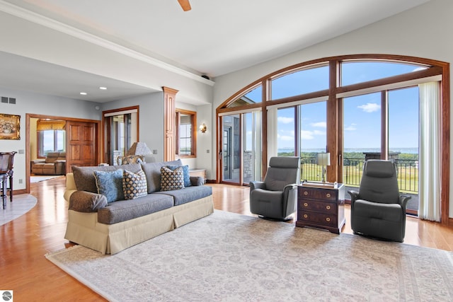 living area with visible vents, wood finished floors, and ornate columns