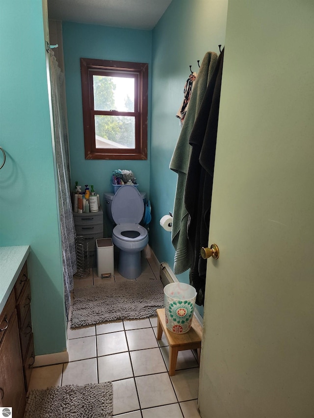 bathroom with tile patterned floors, baseboards, toilet, and vanity