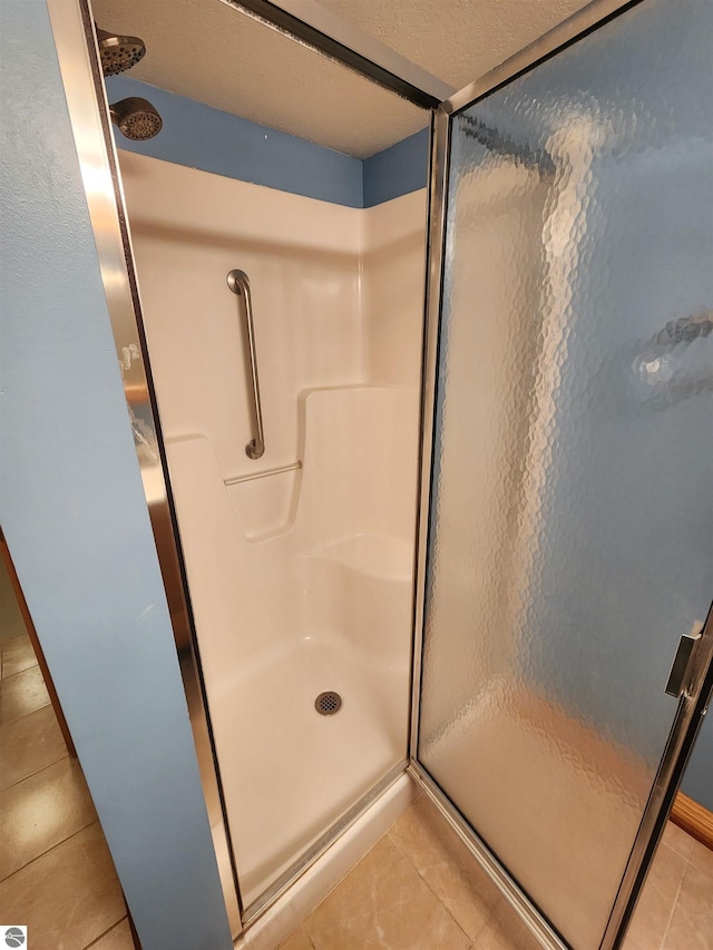 bathroom featuring tile patterned flooring and a stall shower