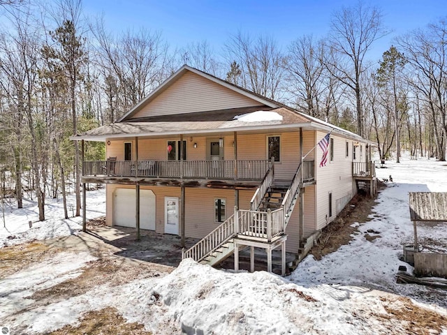 chalet / cabin featuring stairway, a garage, and a porch