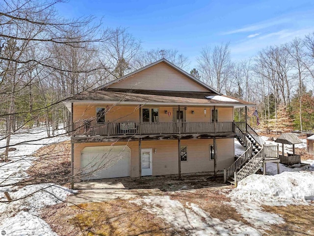 exterior space featuring stairway, an attached garage, and driveway