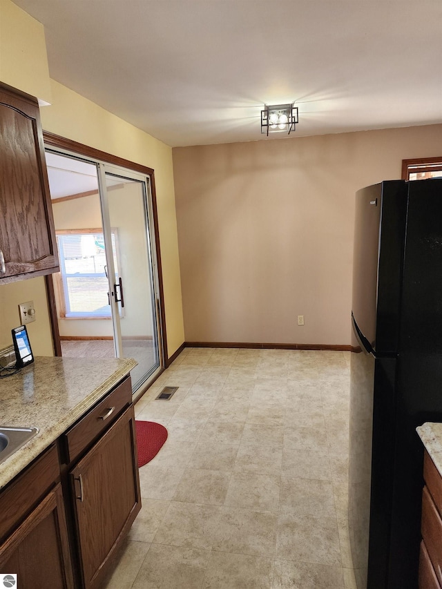 kitchen featuring visible vents, baseboards, and freestanding refrigerator