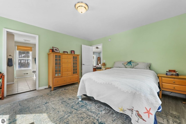 bedroom with wood finished floors, visible vents, and baseboards