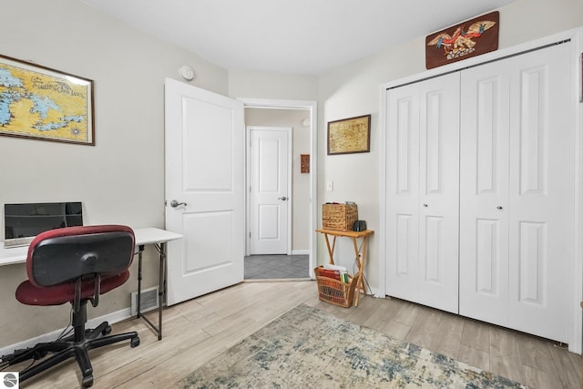 office area featuring visible vents, baseboards, and wood finished floors