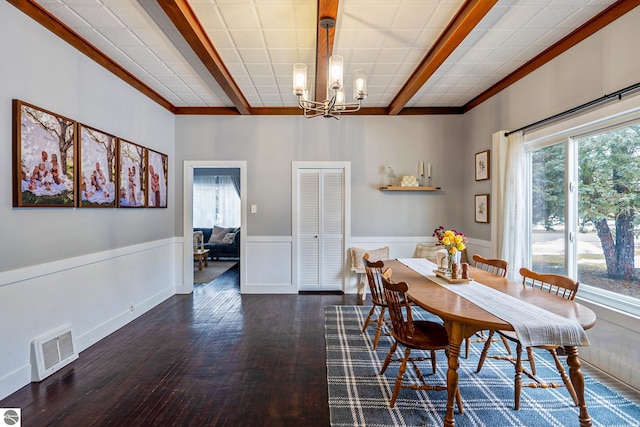 dining space featuring visible vents, beam ceiling, wood finished floors, an inviting chandelier, and wainscoting