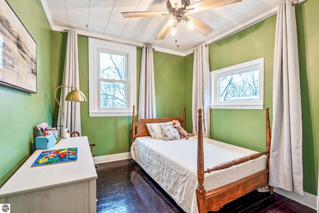 bedroom with multiple windows, dark wood-style floors, baseboards, and ornamental molding