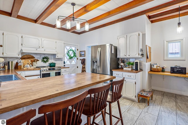 kitchen featuring wooden counters, backsplash, and appliances with stainless steel finishes