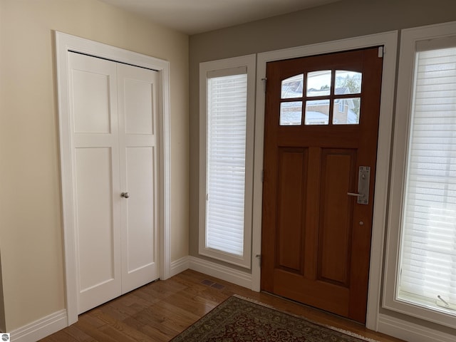 entryway featuring wood finished floors, visible vents, and baseboards