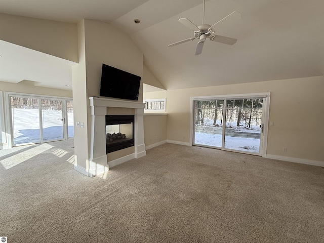 unfurnished living room with ceiling fan, baseboards, a multi sided fireplace, carpet, and high vaulted ceiling