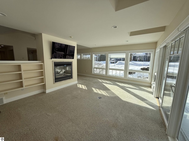 unfurnished living room with visible vents, recessed lighting, a multi sided fireplace, carpet, and baseboards