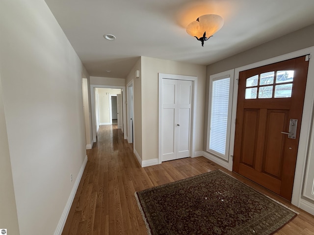 foyer featuring baseboards and wood finished floors