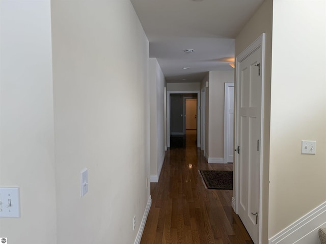 hall featuring wood finished floors and baseboards