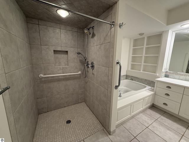 bathroom with a bath, tile patterned flooring, tiled shower, and vanity