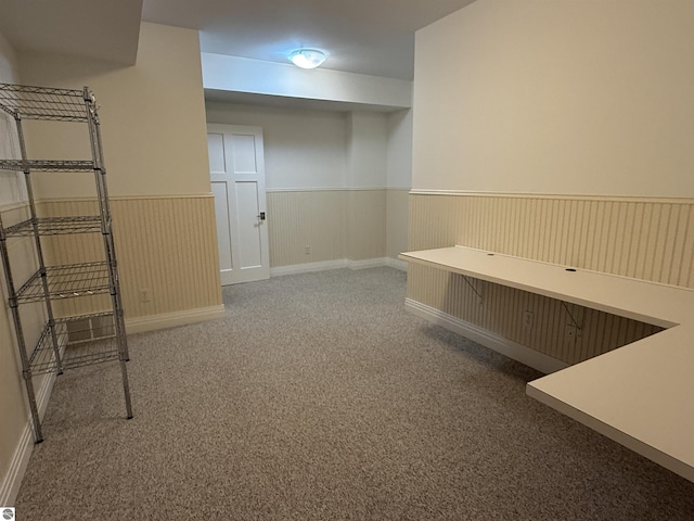 interior space with a wainscoted wall and carpet floors