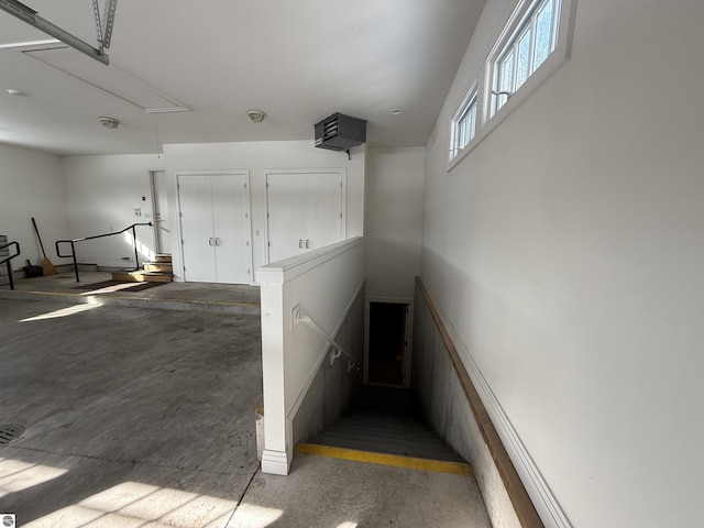 staircase with attic access and concrete floors