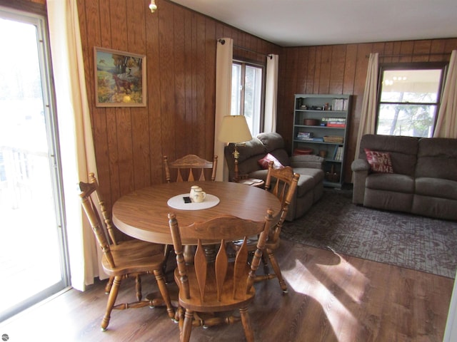 dining space featuring wood finished floors and wood walls