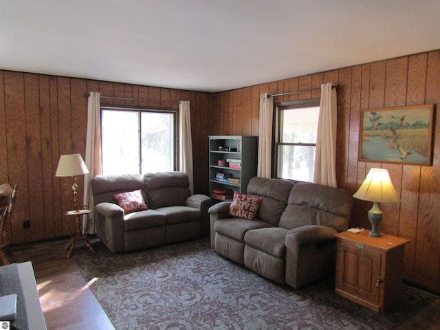 living room featuring a wealth of natural light, wooden walls, and wood finished floors