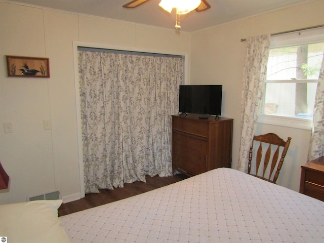 bedroom featuring ceiling fan, visible vents, and wood finished floors