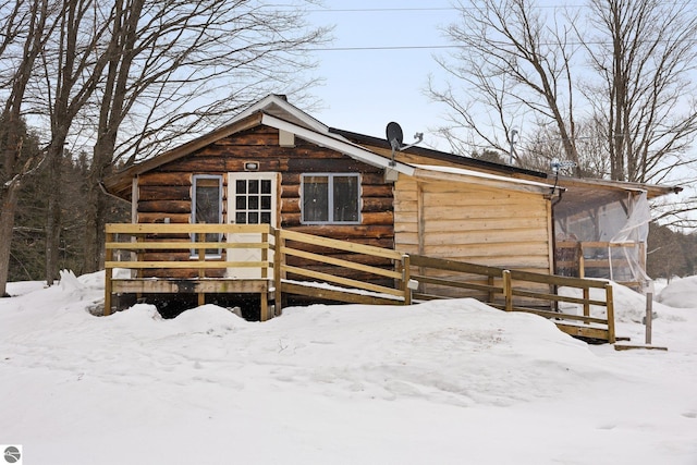 snow covered house with a wooden deck