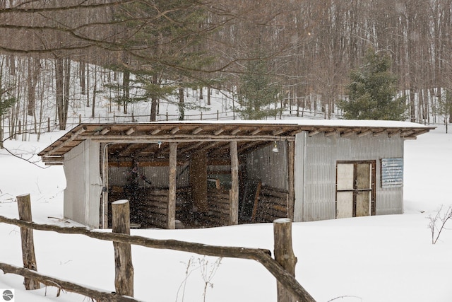 snow covered structure featuring an outbuilding