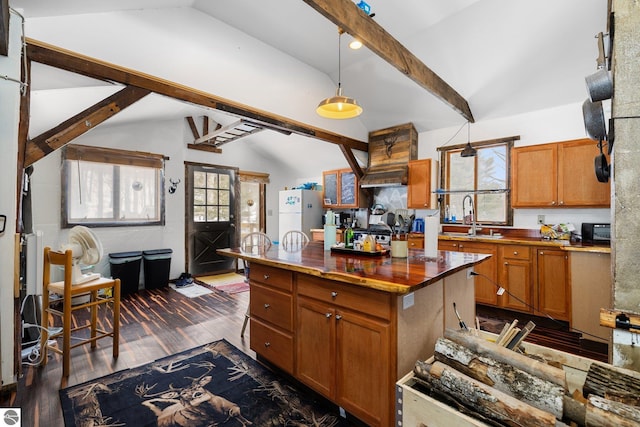 kitchen featuring lofted ceiling with beams, brown cabinets, dark wood-style flooring, and freestanding refrigerator