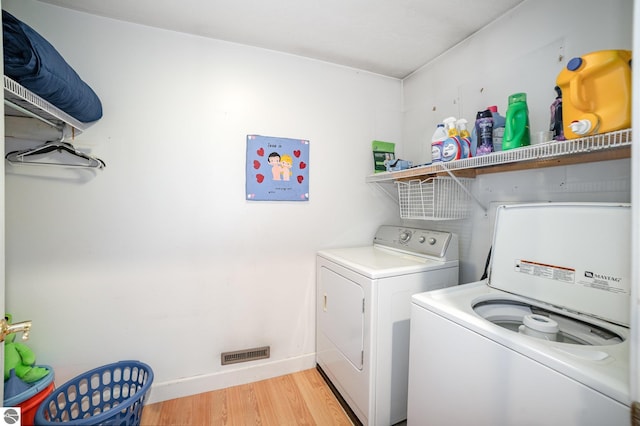 washroom featuring visible vents, baseboards, light wood-type flooring, laundry area, and independent washer and dryer