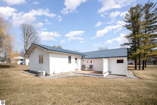 rear view of house with a wooden deck, a yard, and metal roof
