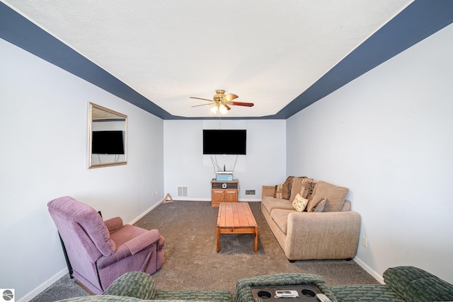 carpeted living area with visible vents, baseboards, and ceiling fan