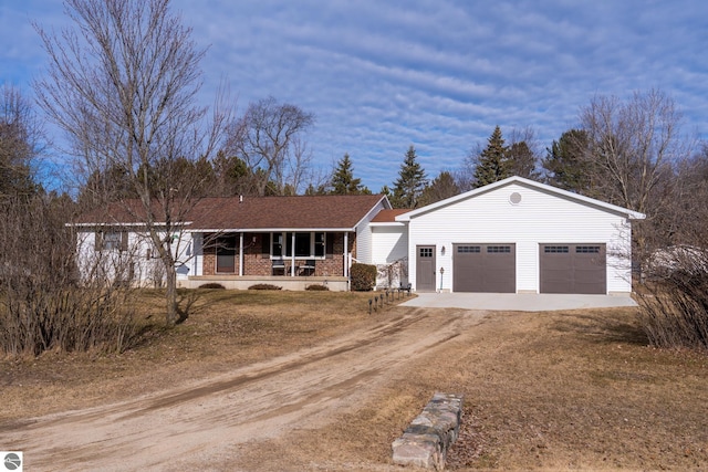 ranch-style home featuring brick siding, a porch, an outdoor structure, and dirt driveway